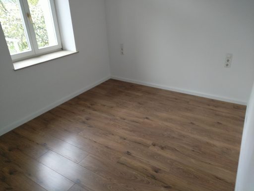 Laminatboden mit weißen Sockelleisten