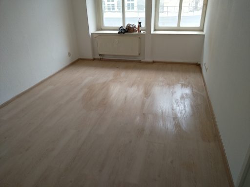 Laminatboden mit weißen Sockelleisten