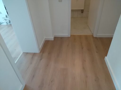 Laminatboden mit weißen Sockelleisten